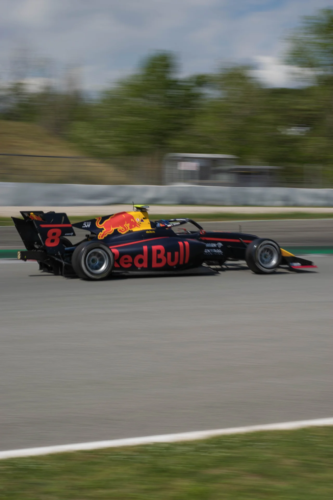 Red Bull Formula racing car racing past the circuit