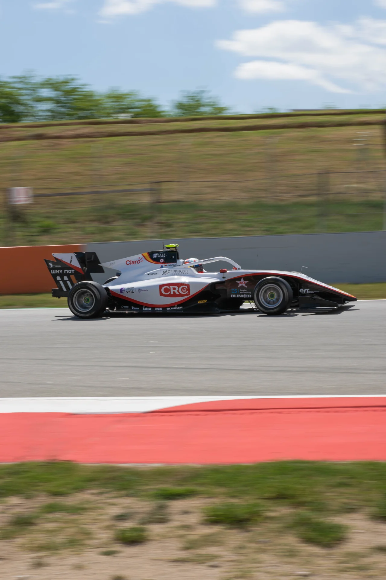 White and red Formula racing car at speed