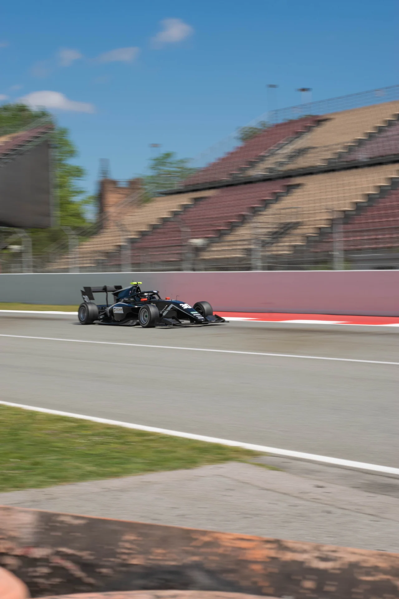 Formula car with the circuit grandstands in the background